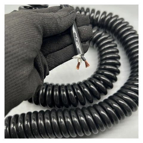 Rock Solid Retractable Coiled Power Cord with Copper Core held with black gloves, showing flexible 20m design, ideal for heavy duty tasks.
