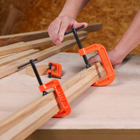 Heavy Duty Malleable Iron C Clamp Set Three Piece With 1 Inch 2 Inch And 3 Inch Jaw Openings in use on wooden boards