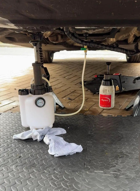 Must Have 3L Manual Transmission Fluid Transfer Pump Kit under car in use with gauge and hose attached