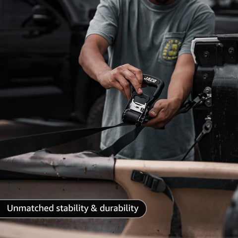 Person using Heavy Duty Ratchet Straps With Soft Loops 1.6 Inches By 8 Feet Pack Of Four For Motorcycles ATVs And Trailers 5208 Lbs Break Strength Tough As Nails Hauling Kit In Black to secure gear.