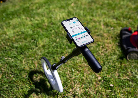 Rock Solid Digital Measuring Wheel And Smart Mapping Kit With Sprayer Attachment and Heavy Duty Carrying Case displaying app on grass.
