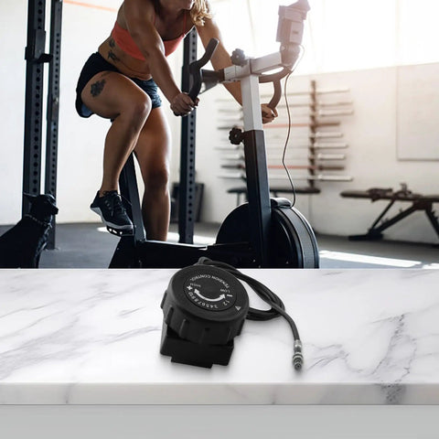 Fine Tuned Resistance Rotary Adjuster for Exercise Bike with Eight to Ten Gear System on gym floor, cable visible