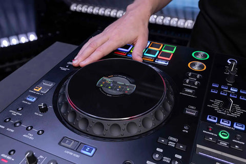 Hand using Four Deck All In One DJ System With A 10.1 Inch Touchscreen Built In Wi Fi SonicLink Wireless Tech Performance Pads And Beat FX