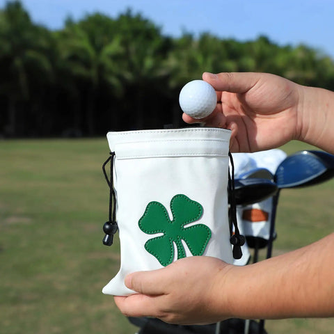 Person holding a Leather Golf Valuables Pouch With Drawstrings, Tee Pouch For Golfers, On The Go Golf Ball Bag For Men And Women with shamrock design