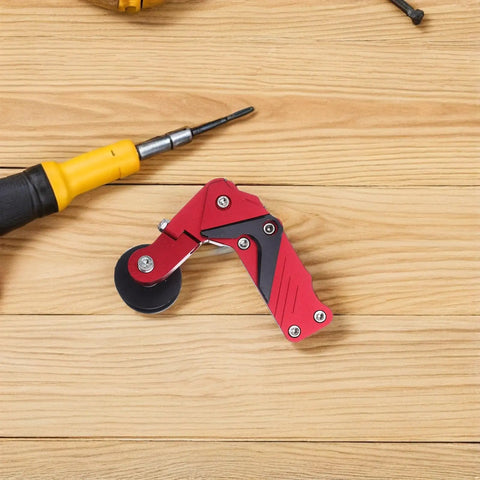Thinking Process: red aluminum motorcycle chain adjuster with roller wheel, shown on wood surface for ATV chain tension use