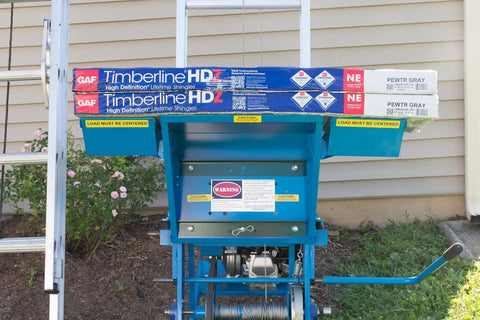 Pro Grade Gas Material Hoist 300 Lb Capacity Roof Lift with shingles loaded, showing steel frame and warning labels.