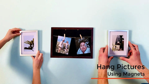 Hands placing photo frames on wall painted with Magnetic Paint and Primer for Any Surface Water Based 16oz Turn Walls Into A Magnet Friendly Space For Photos Kids Artwork Letters And Reminders Great With Any Color Paint Or Chalkboard Finish