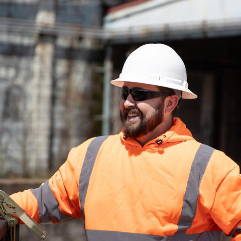 Worker wearing Tinted Safety Glasses 12 Pack ANSI Z87 Plus UV Eye Protection For Construction, Outdoor Work, And Industrial Safety