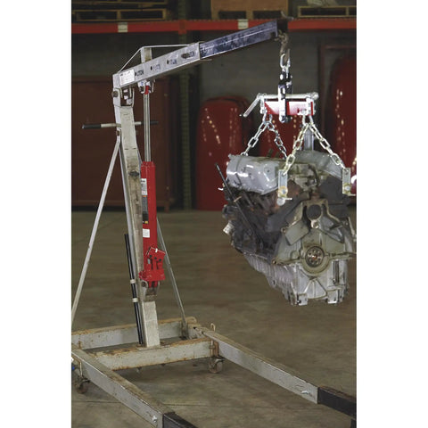 Heavy Duty 8 Ton Long Ram Hydraulic Floor Jack With Rapid Double Piston Pump for smooth lifting of an engine in a garage setting.