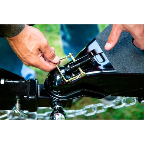Person using Heavy Duty Snapper Pins 2 Pc Set 1/4 Inch By 2 3/4 Inch on trailer hitch for secure attachment.