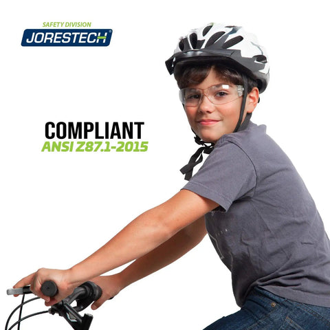 Kickass Kids Safety Glasses Featuring Hella Clarity Impact Resistant Polycarbonate Lenses With Heavy Duty UV Blocker For Daily School Use And Tough Playgrounds Alongside Anti Scratch Frameless Comfort worn by boy on bicycle with helmet.