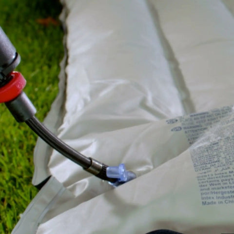 Cordless Tire Inflator With Digital Gauge And LED Light inflating an air mattress with quick connect nozzle on grass