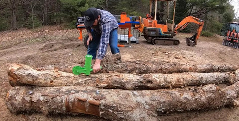 Person using Dead On Firewood Measuring Tool And Log Line Marking Accessory With 16 Inch Rolling Wheel on logs outdoors.