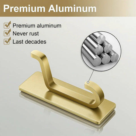 Secure All Your Gear With These Rock Solid Self Adhesive Wall Hooks Built For Heavy Duty Bathroom And Kitchen Use Featuring Killer Sticky Grab Technology No Drilling Required Smooth Brushed Gold Four Pack Deal, close-up of a premium aluminum gold wall hook.