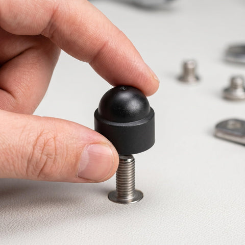 Hand holding M8 Black Plastic Hexagonal Dome Nut Cap on a bolt, part of 50 Pack Impact Resistant Protective Covers for Hex Nuts.