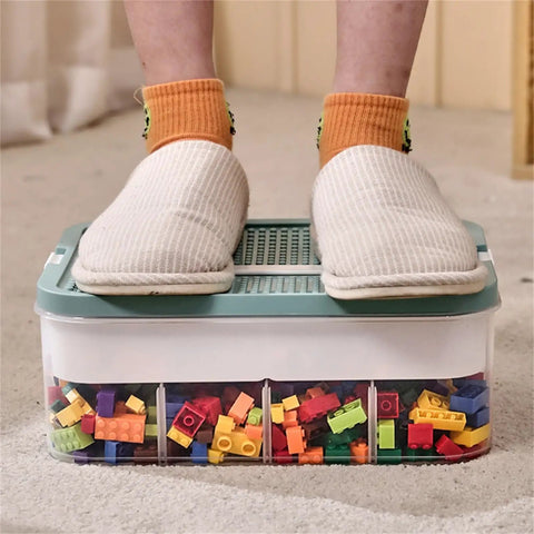 Slick 3 Tier Stackable Brick Storage Organizer With Removable Grid Trays For Lego Pieces, person standing on clear organizer filled with colorful bricks.