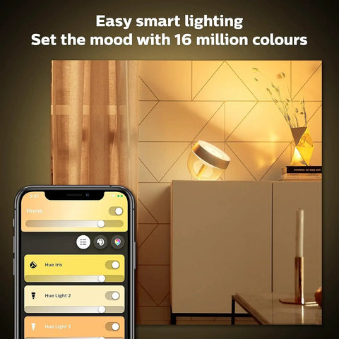 Gold Smart Table Lamp With White And Color Ambiance LED That Changes Color on a sideboard, smartphone app control visible