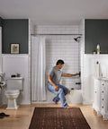 Person adjusting Elmhurst Shower Trim Kit For Shower Only Without Tub Spout Oil Rubbed Bronze Finish in modern bathroom setting