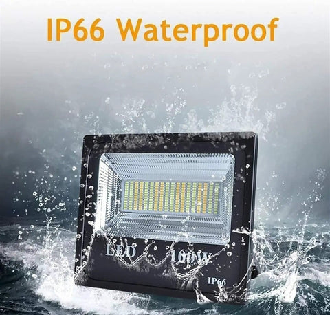 JUDYSSY Led Floodlight 100W Led Solar Flood Lights, IP66 waterproof design, illuminated in splashing water.