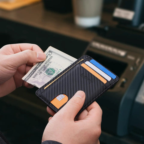 Ultra Slim Front Pocket RFID Blocking Leather Wallet For Men And Women In Carbon Fiber Black shown holding cash and cards.
