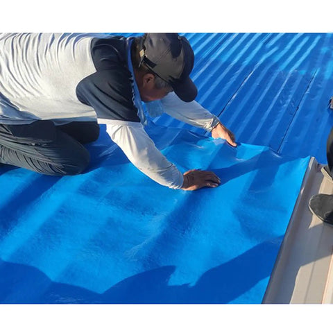 Man applying Badass Hella Tough Self Adhesive Roofing Felt Tape Waterproof Asphalt Repair Shingle Roll on a roof.