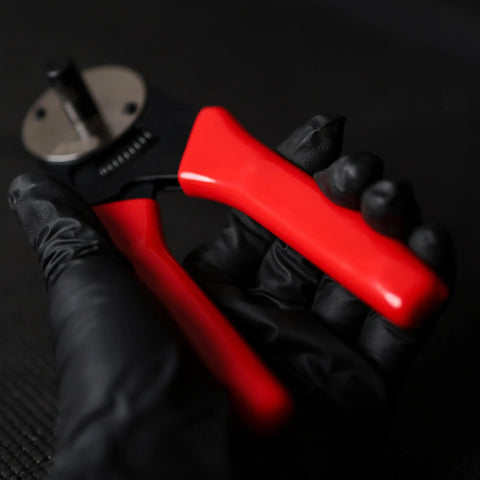 Deutsch Closed-Barrel D-Sub Crimper for 12-20 AWG with Ratcheting Action, showing red cushioned handles in gloved hand