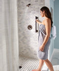 Brantford Oil Rubbed Bronze Posi-Temp Shower Trim Kit with showerhead and lever handle in use in bathroom.