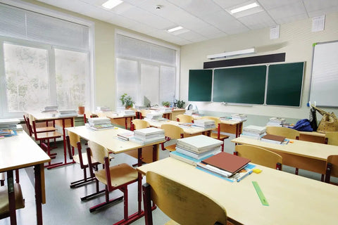Classroom with desks and chairs, illuminated by Boss 2x2 LED Troffer Light With Stack Switch Drop In Ceiling Fixture For Dropped Ceilings Adjustable Lumens 3000 4000 5000 And Switchable Color Temperature 3500K 4000K 5000K White.