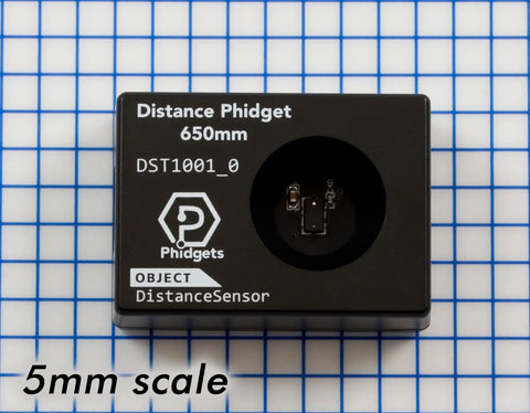 Slick Infrared Time Of Flight Distance Sensor Solid For Makers Delivering Tight Measurements Across Twenty To Sixty Five Millimeter Range With Fast Continuous Data Streams on a grid background with 5mm scale.