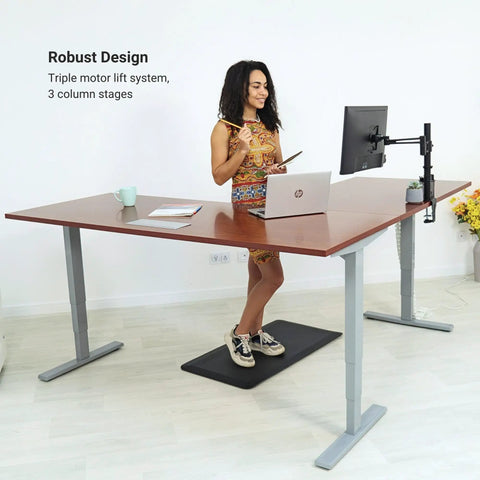 L Shaped Electric Standing Desk With Effortless Height Adjustment Serving As A Rock Solid Corner Workspace Measuring 72 By 60 Inches Straight Up Crafted For Daily Use Boasting Heavy Duty Gray Frame Paired With A Top Shelf Gray Oak Desktop.