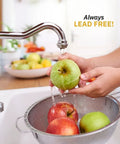 Person washing apples under faucet, showcasing stainless steel sink and lead-free water use in kitchen setting