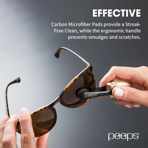 Close-up of a hand using Peeps eyeglass lens cleaner on tortoiseshell sunglasses, black carbon microfiber pad.