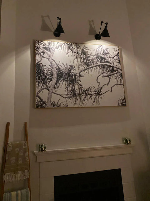 Frosted Black Vintage Industrial Wall Lamp Set illuminating artwork, adjustable sconce lighting for bedroom or living room.