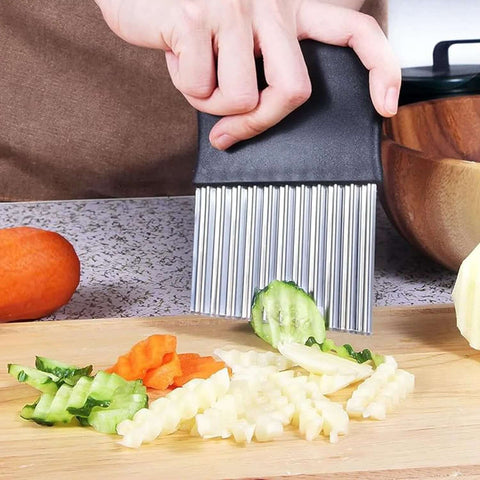 Crinkle cutter with stainless steel comb blade and black handle for kitchen use, slicing cucumbers and carrots.