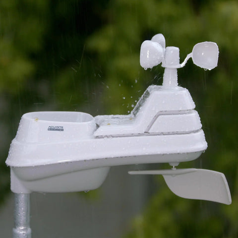 Side view of the 5 In 1 Wireless Indoor Outdoor Weather Station With Color Display For Real Time Backyard Weather And Hyperlocal Forecast Tracks Temperature Humidity Wind Speed And Direction Barometric Pressure And Rainfall With No Fuss Self Calibrating Tech unit in rain with sensors visible.