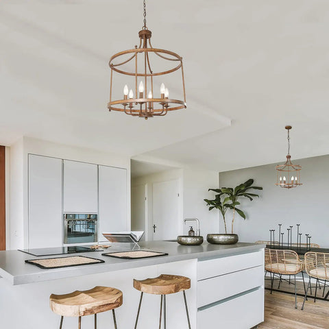Rustic Bronze Farmhouse Six Light Drum Chandelier hanging over modern kitchen island with wooden stools and decor