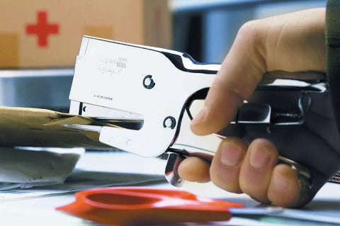 Heavy Duty Nickel Plated Staple Pliers With Attached Finger Stop And Standard Straight Anvil in use, binding paper securely.