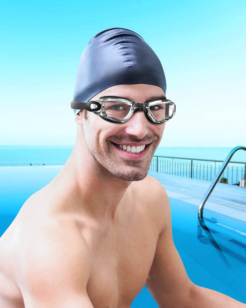 Elite Leak Proof Swim Goggles Serve Up Premium Anti Fog Visibility And Round The Clock UV Blocking on a smiling swimmer by the pool.