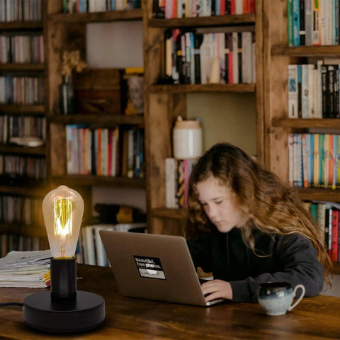 Industrial Desk Lamp Base With Ceramic Holder E26 E27 Compact Old School Vintage Edison Style Small Desk Light for Home Office Decor on a desk next to a person using a laptop in a library.