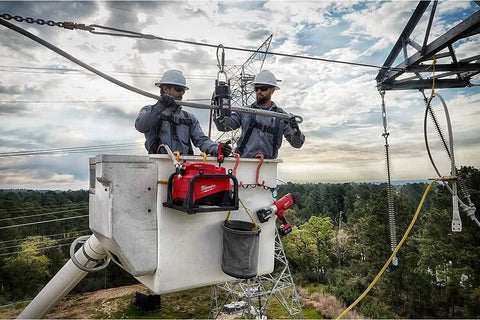 Two professionals using Top Shelf No Nonsense Cordless Hydraulic Pump Kit Featuring M18 Battery Technology And 10000 Psi Pressure in a lift.