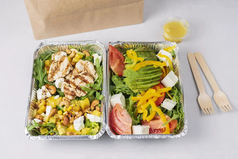 Two disposable aluminum pans with salads, featuring grilled chicken, vegetables, and cheese, part of Disposable Aluminum Pans With Lids 50 Pack