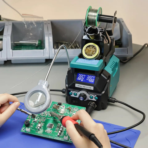 Hands using Pro Grade 110W Digital Soldering Station Kit with LCD Display and Sleep Mode on circuit board with magnifier
