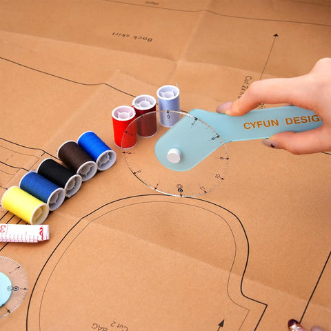 Knock Your Pattern Drafting Tasks Out Of The Park With This Precision 12 Inch Acrylic Sewing Wheel Ruler tracing patterns with thread spools.