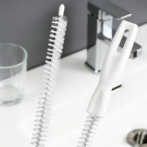 Flexible Drain Snake Cleaner Brush That Kicks Out Greasy Gunk Reusable Spiral Hair Removal Tool With Comfort Grip Handles For Sinks Showers And Bathtubs In White on a bathroom sink.