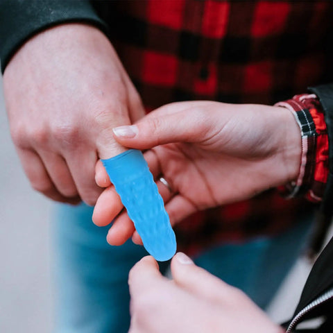Person applying a blue nitrile antistatic finger sleeve for protection during electronics assembly tasks.