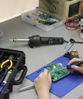 Person using All In One Portable Soldering And Hot Air Rework Kit With PID Temperature Control 65W Soldering Iron on circuit board