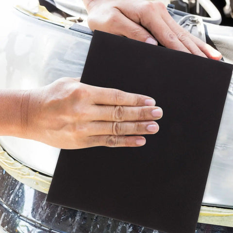 Hand using a piece from Nine Piece Sanding Paper Assortment With Diverse Grits for smooth metal polishing.
