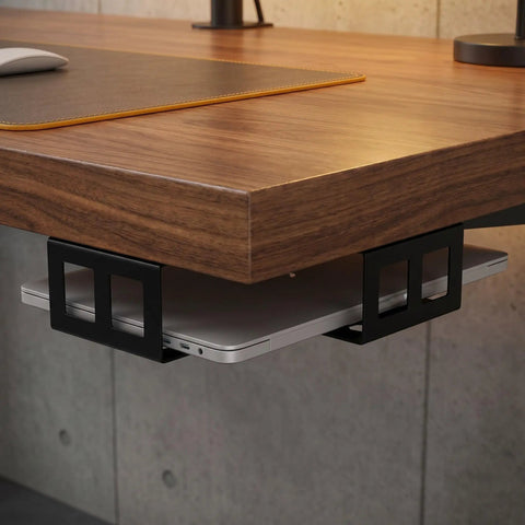 Heavy Duty Under Desk Laptop Mount Rack With Anti Slip Pads Plus Renter Friendly Hardware For Easy Install and Solid Dual Bracket Storage System To Kick Clutter To The Curb While Keeping Workspace Organized Tight under a wooden desk with a laptop.