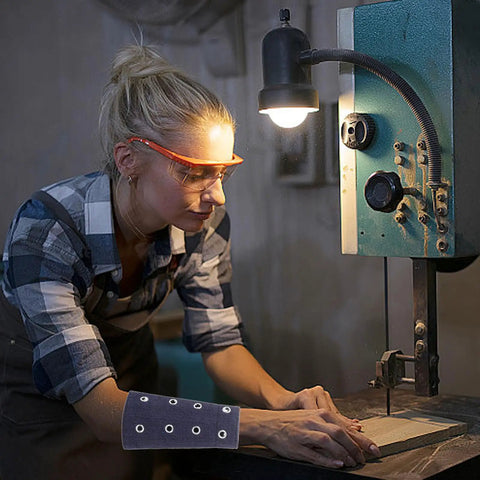 Woman using Super Lightweight Breathable Cut Resistant Wrist Sleeves And Flexible Arm Guards For Yard Work And Auto Repair while operating machinery.