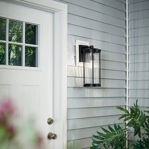 Lit 16 Inch Outdoor Wall Light 1 Light Sconce with Clear Ribbed Glass in Black Finish beside white door